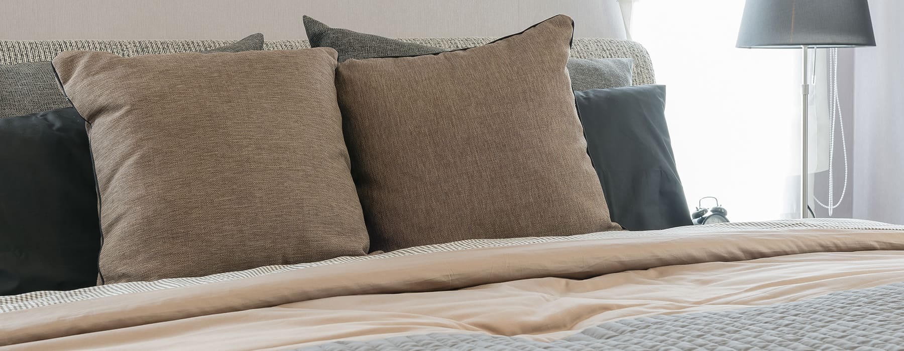 close-up of pillows in a warm toned bedroom